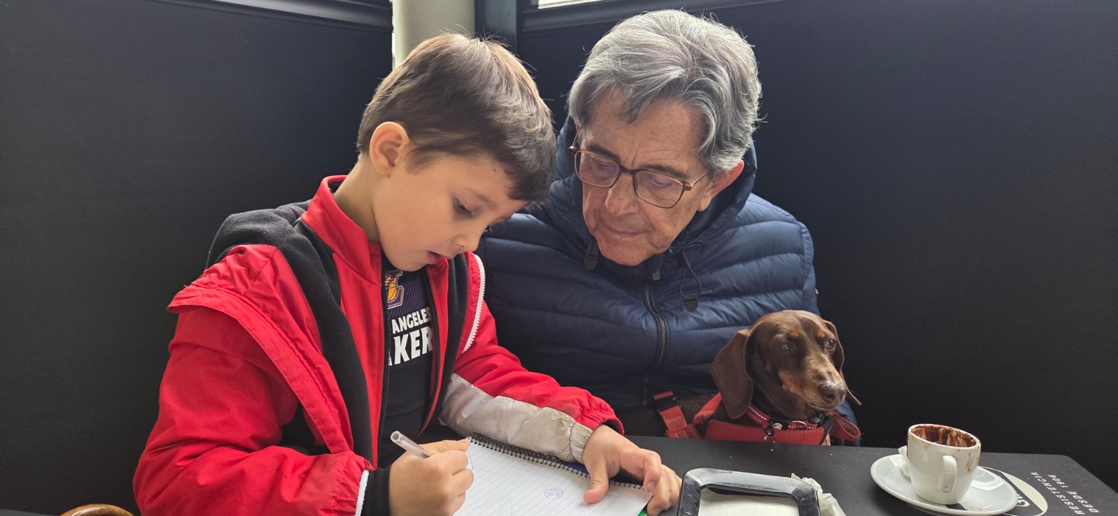 Elliot drawing while Eladio looks on at the cafe yesterday